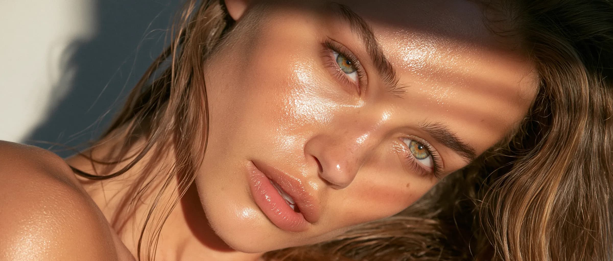 Dappled sunlight falling across the face of a woman with firm, resilient skin